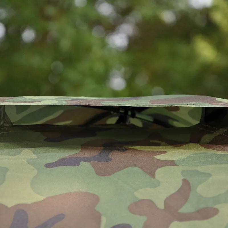 Green camouflage tent with triangular skylight and fibreglass poles set up outdoors