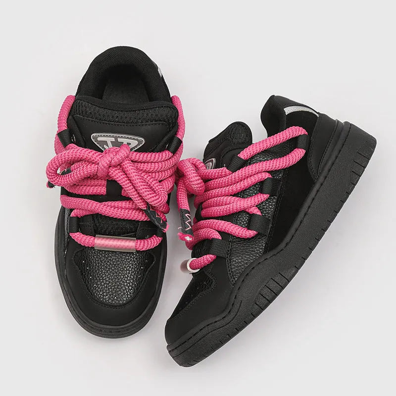 Pair of thick-soled casual lace-up trainers in a solid colour on a white background.