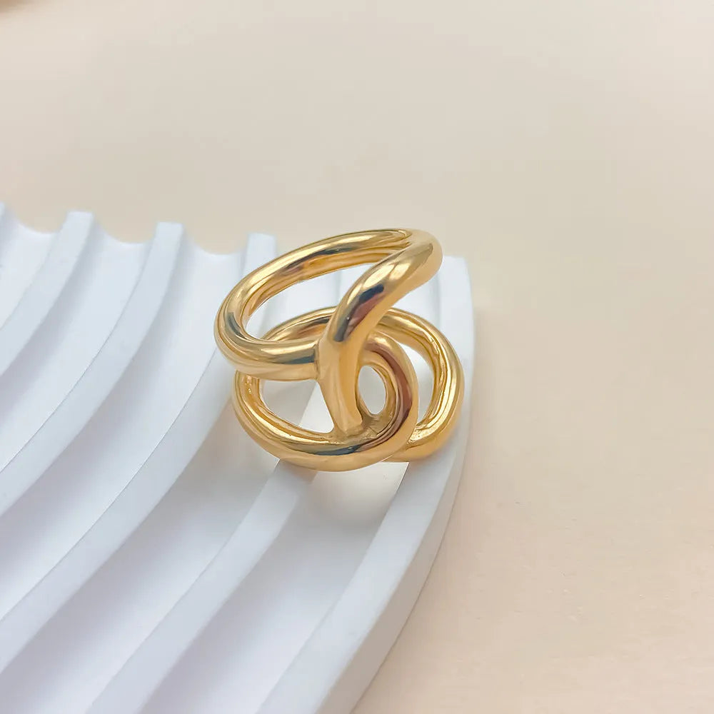 Adjustable knotted opening ring in stainless steel, shown in both gold and steel colour finishes on a woman's hand.
