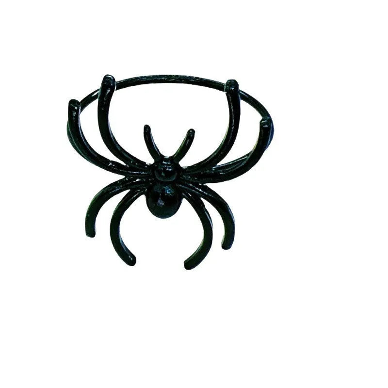 Six black metal spider-shaped napkin rings for Halloween table decoration.