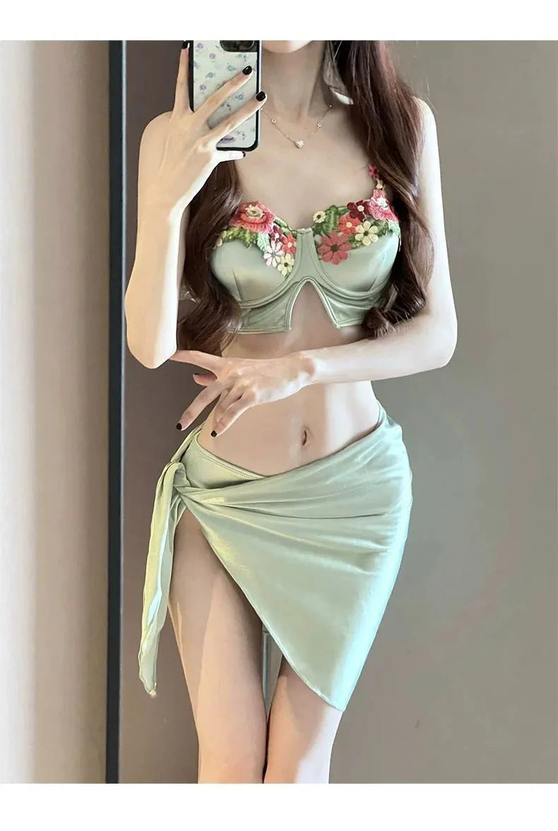 Green women's three-piece bikini set with triangle cup top, briefs, and skirt cover-up