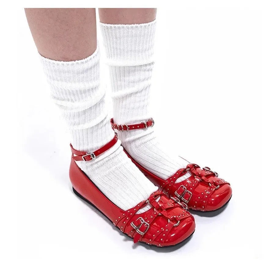 Women's black patent leather buckle pumps with a square toe and low flat heel on a white background.