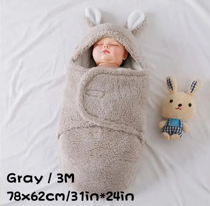 A baby wearing a soft grey fleece sleeping bag with hook-and-loop shoulder straps.