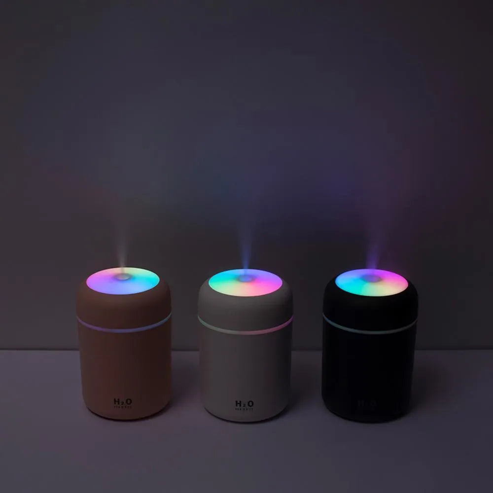 Pink USB portable humidifier with atmosphere lights on desk surface