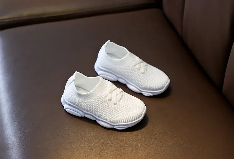 Children's white lazy slip-on shoe with fabric upper and textured non-slip rubber sole.