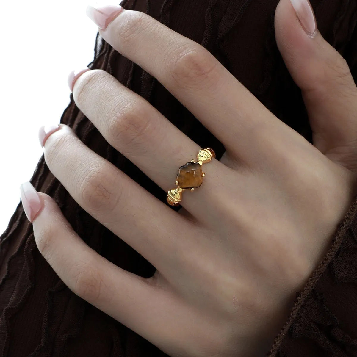 Women's silver ring with shell design and Tiger Eye stone on an adjustable band.