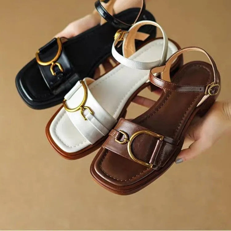 Women's black thick-soled leather sandals with a round toe and button closure on a white background.