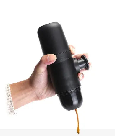 Black portable manual coffee machine showing compact size and manual operation components.