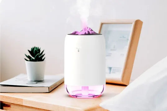Mini cylindrical USB ultrasonic humidifier in white, pink, or green with warm night light on.