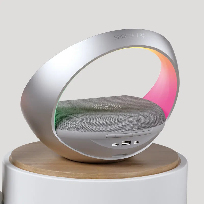 Beige and grey multifunctional wireless charging clock with Bluetooth speaker and LED light display.