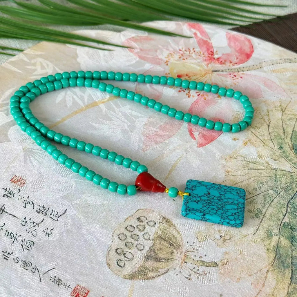 Turquoise mesh flower lucky pendant necklace on an adjustable ball bead chain.