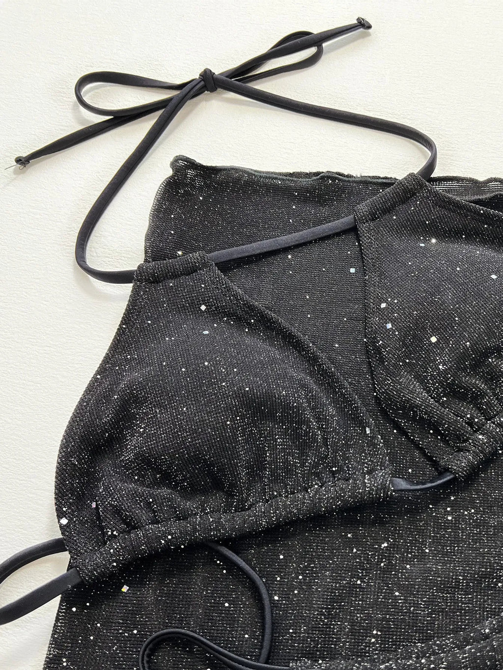 Black women's three-piece bikini swimsuit set with top and shorts on a mannequin.