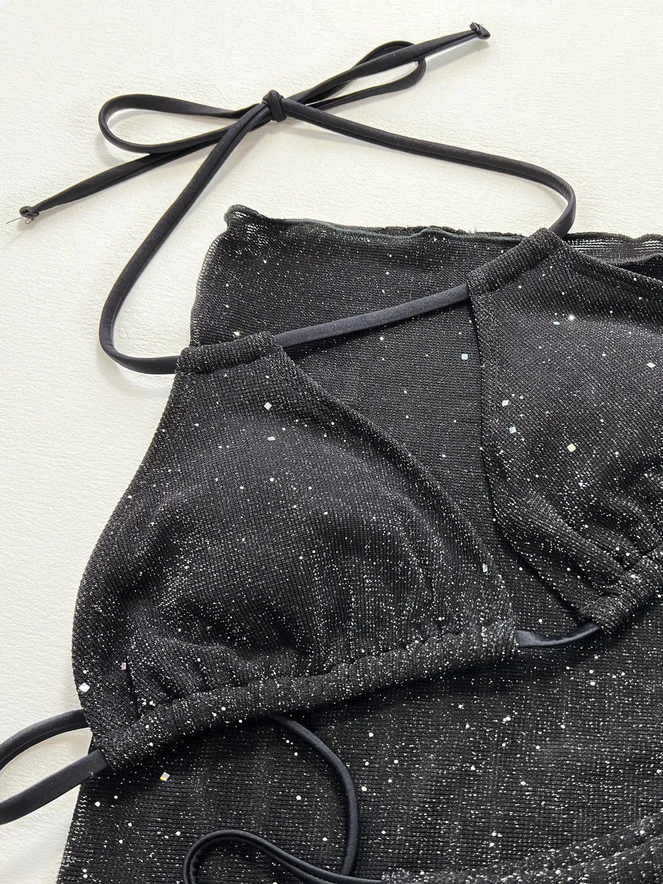 Black women's three-piece bikini swimsuit set with top and shorts on a mannequin.