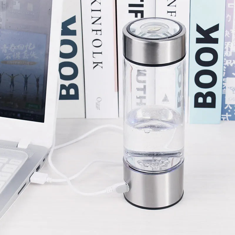 Silver hydrogen water bottle with electric generator, borosilicate glass cylinder.