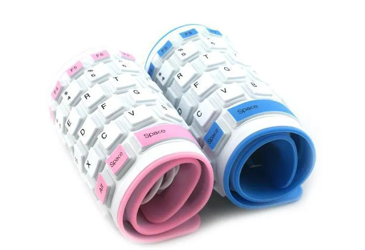 Folding waterproof silicone keyboard in pink with USB cable on a desk