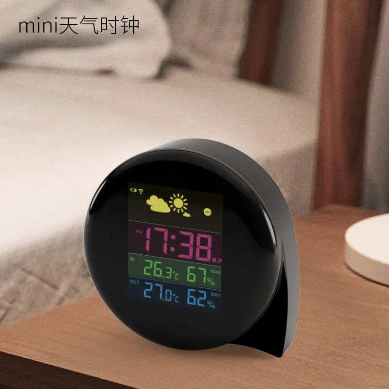 Black wireless weather forecast clock with outdoor sensor showing temperature and humidity on colour LED display