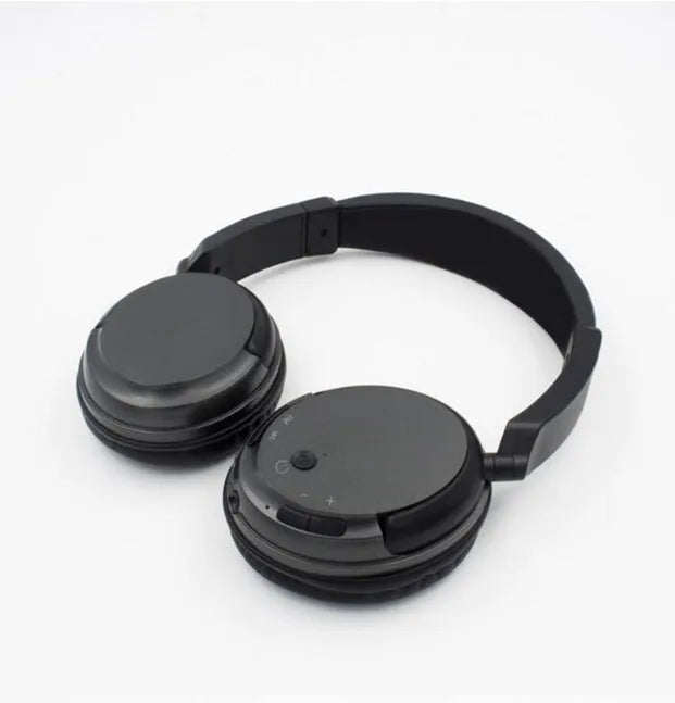 Black stereo wireless headset with USB FM transmitter and audio cable on a dark background