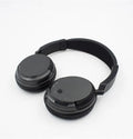 Black stereo wireless headset with USB FM transmitter and audio cable on a dark background