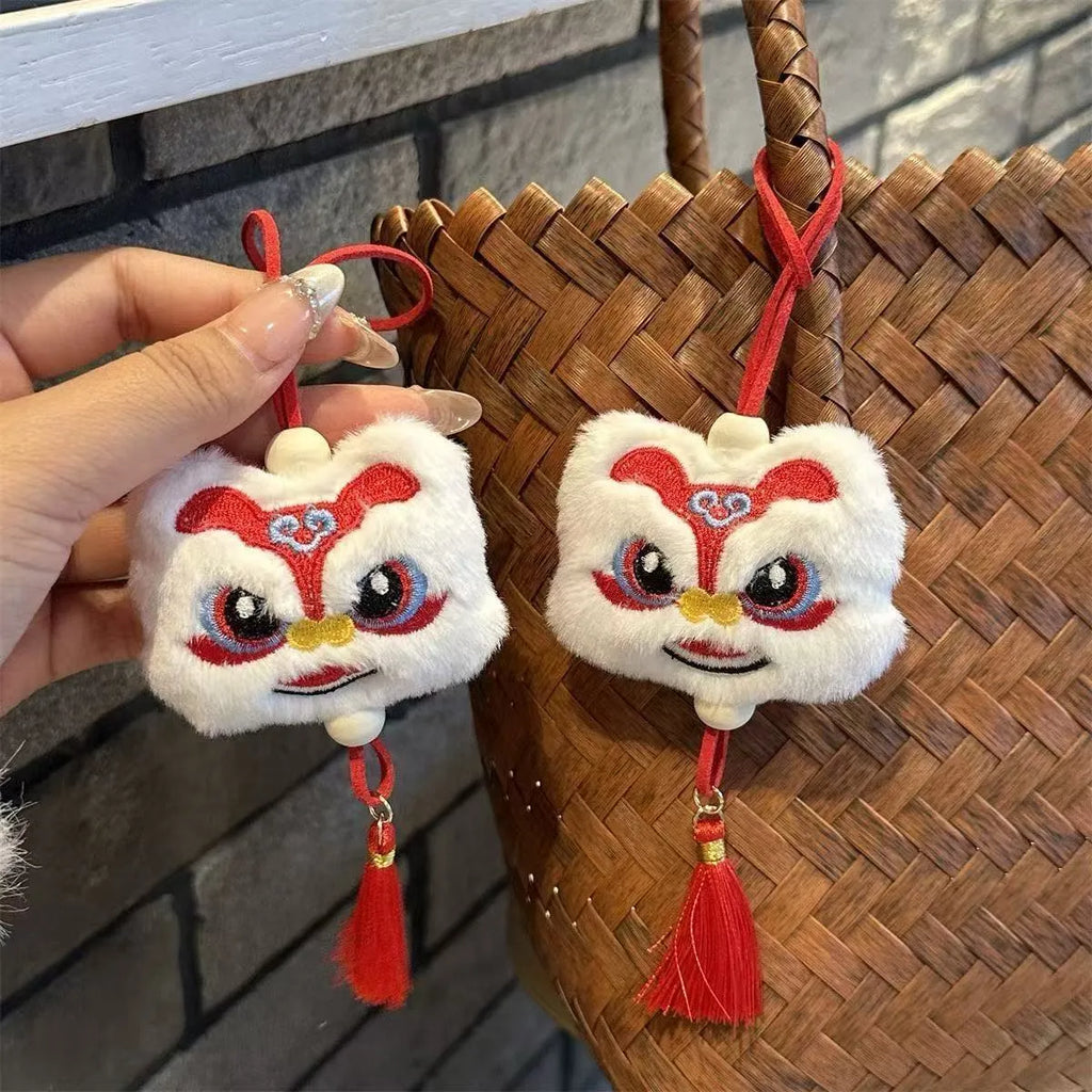 Handmade Chinese lion plush ornament with star stone details on blue and yellow keychain