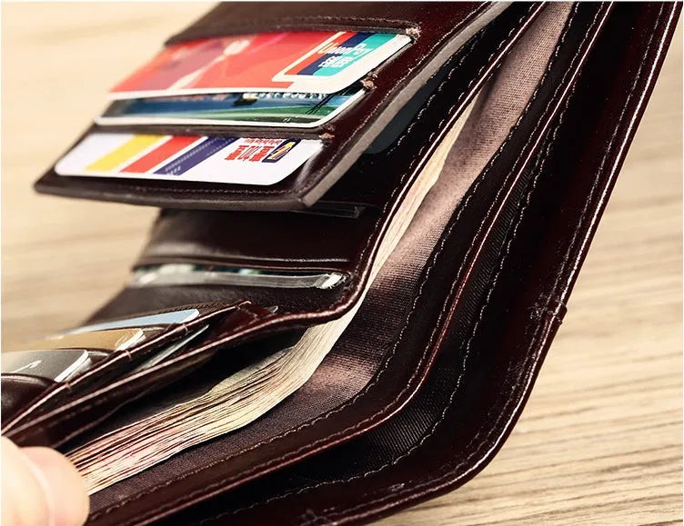 Men's brown leather bifold wallet open to show multiple card slots, a cash compartment, and a coin pocket.
