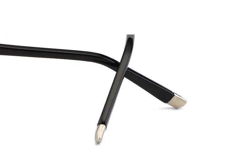 Diamond-cut metal reading glasses with tan frame and black lenses on a plain background