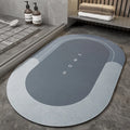 Bathroom floor mat in blue oval shape placed near a sliding shower door.