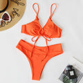 Women's orange tied bow bikini with halter neck top and high-cut briefs on mannequin