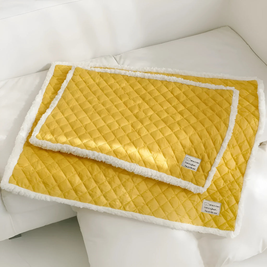 Quilted cloth pet blanket for cats in blue, shown on a cat bed, with size options M, L, and XL.