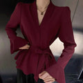 Women's black French-style shirt with an irregular collar and long bell sleeves, showing the tied front detail.