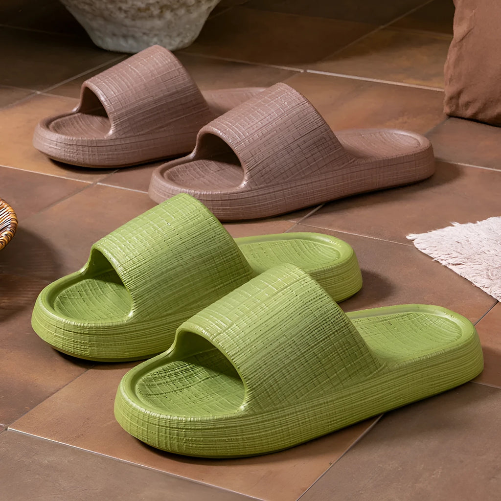 Women's soft EVA non-slip bath slipper in black, showing toe ring flip-flop design and textured sole.