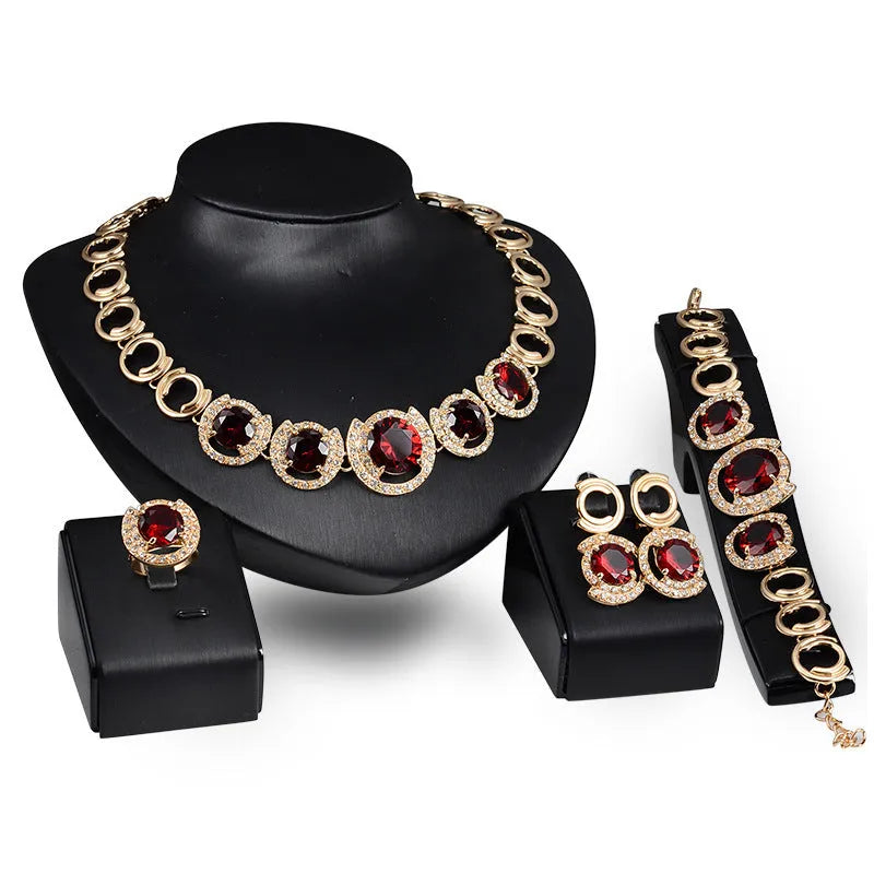 Gold-tone bridal jewellery set with crystal pendant necklace, earrings, ring, and bracelet with green red zircon stones