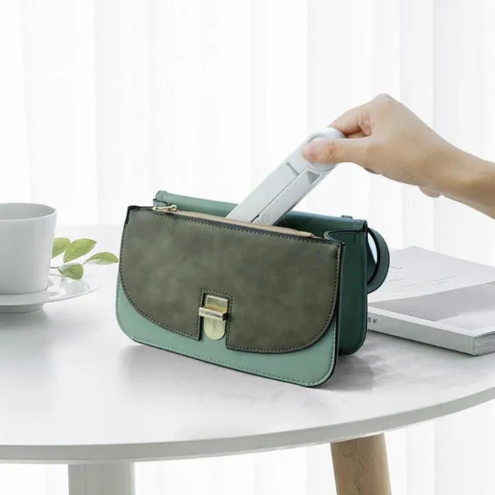 Black foldable tablet holder standing upright with a tablet in landscape mode on a desk