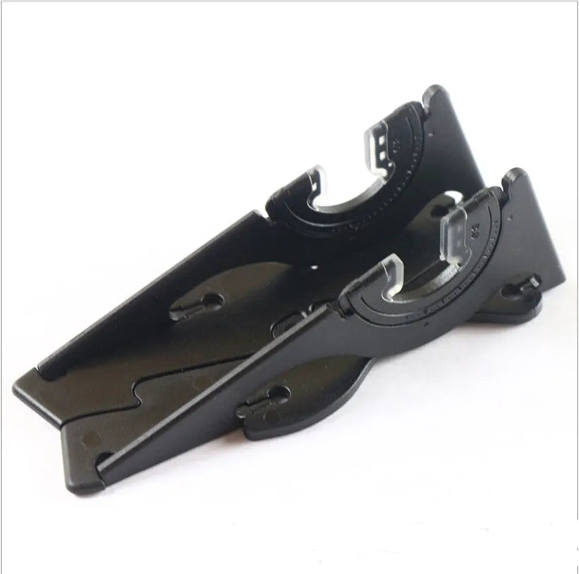 A black plastic card-type mobile phone holder with its lazy bracket unfolded, standing on a desktop.