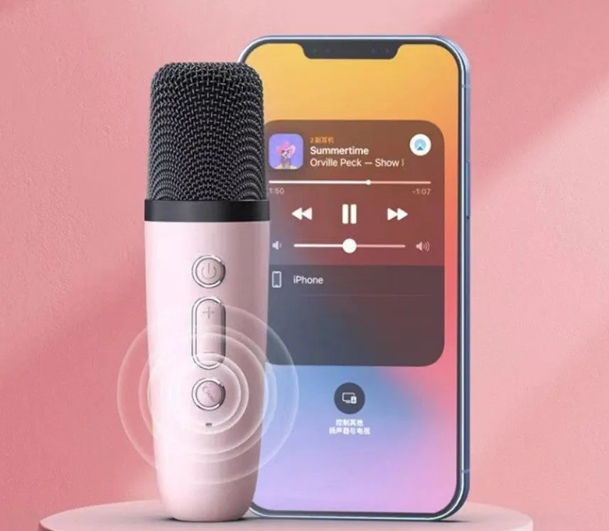 Pink portable Bluetooth speaker with microphone and coloured LED lights on a table.