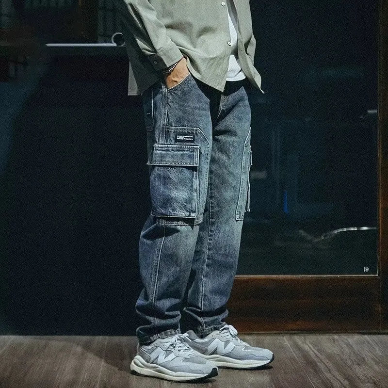 A pair of men's loose straight leg blue jeans on a plain background, showing the zip fly and classic denim style.