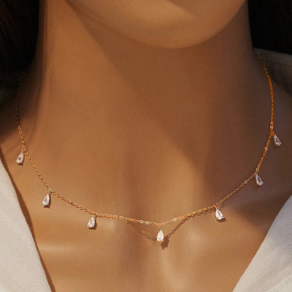 Silver necklace with a drop-shaped pendant holding a triangular zircon on an O-chain.