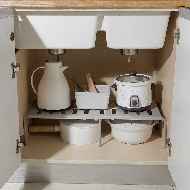 White telescopic plastic kitchen storage rack at adjustable height