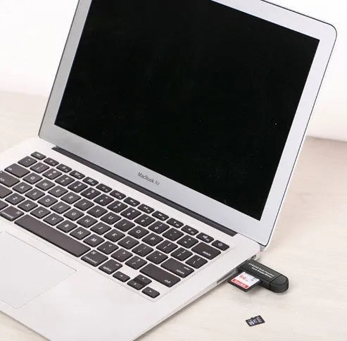 Black smart three-in-one card reader with micro USB and USB 2.0 plugs on a light surface