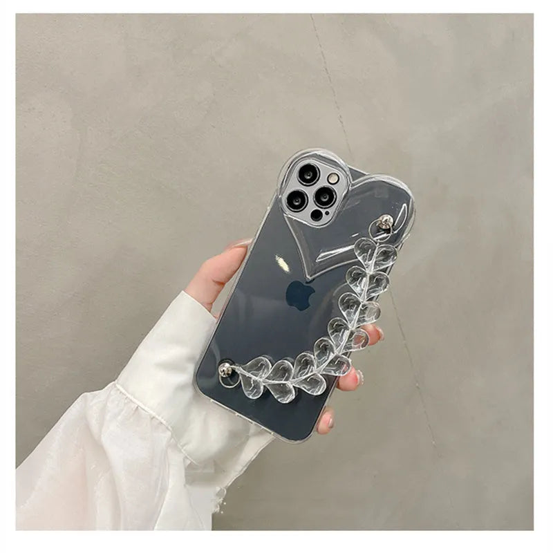 Transparent soft TPU iPhone case with a built-in clear love heart charm and chain.