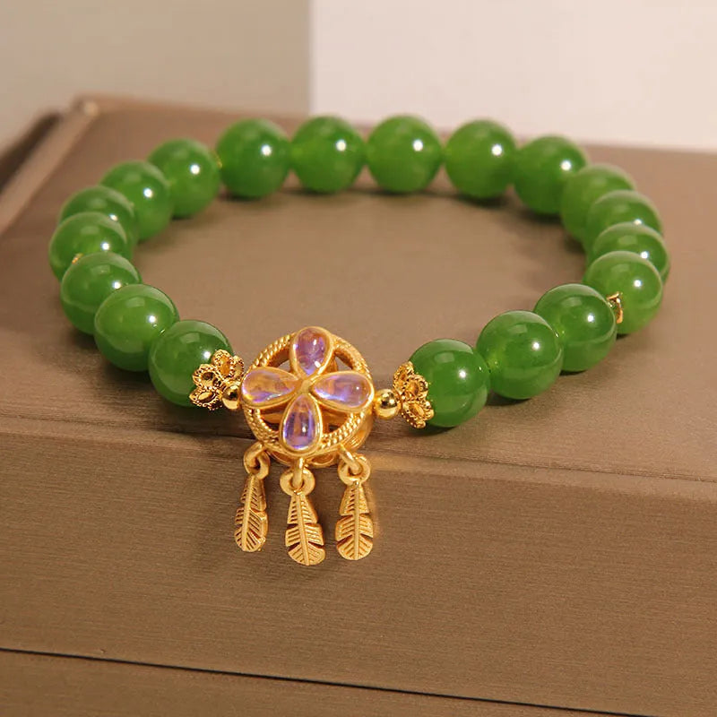 Green jasper crystal four-leaf clover dream catcher pendant bracelet on a natural cotton cord.