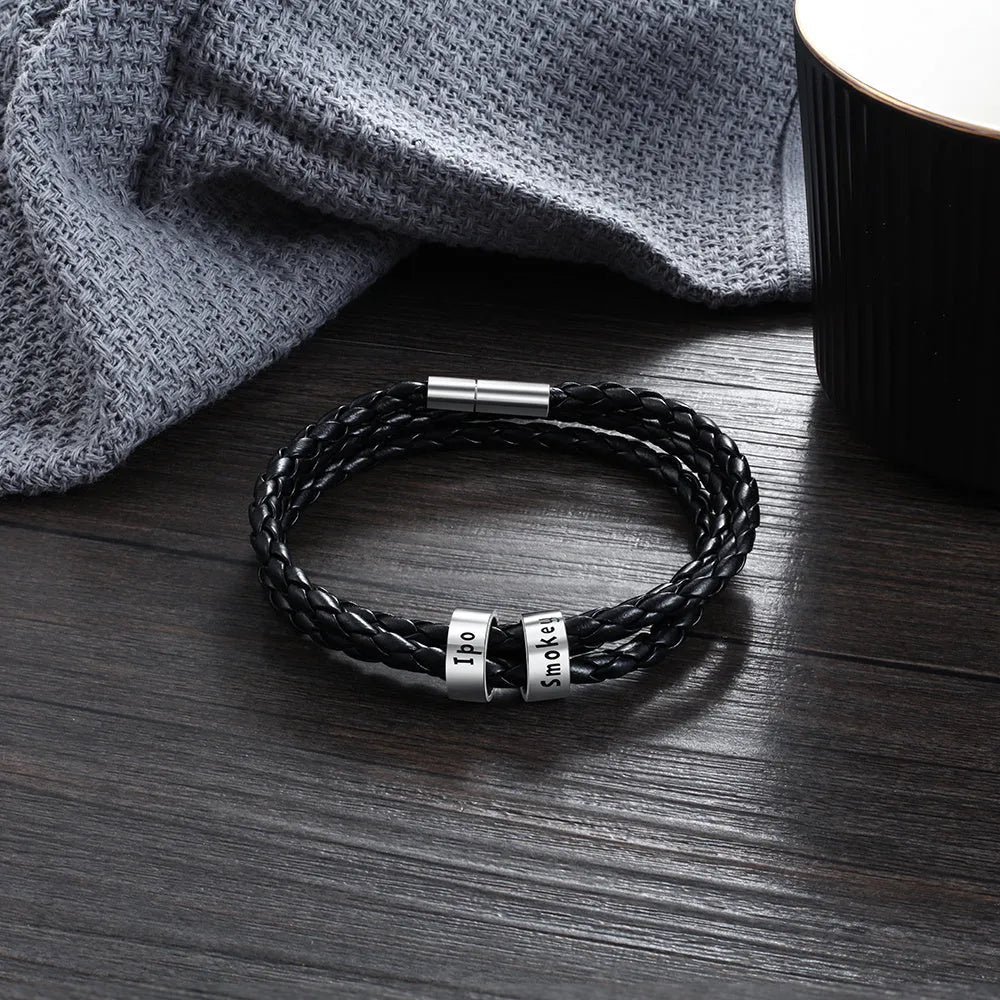 Personalised mens braided genuine leather bracelet in black with custom stainless steel name beads showing engraved names