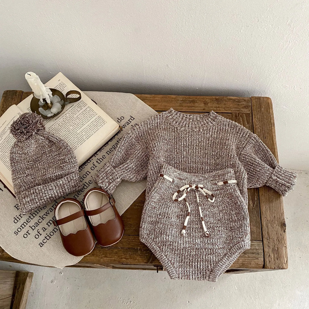 Dark brown knitted baby girl three-piece set with removable fur ball hat, blouse, and shorts