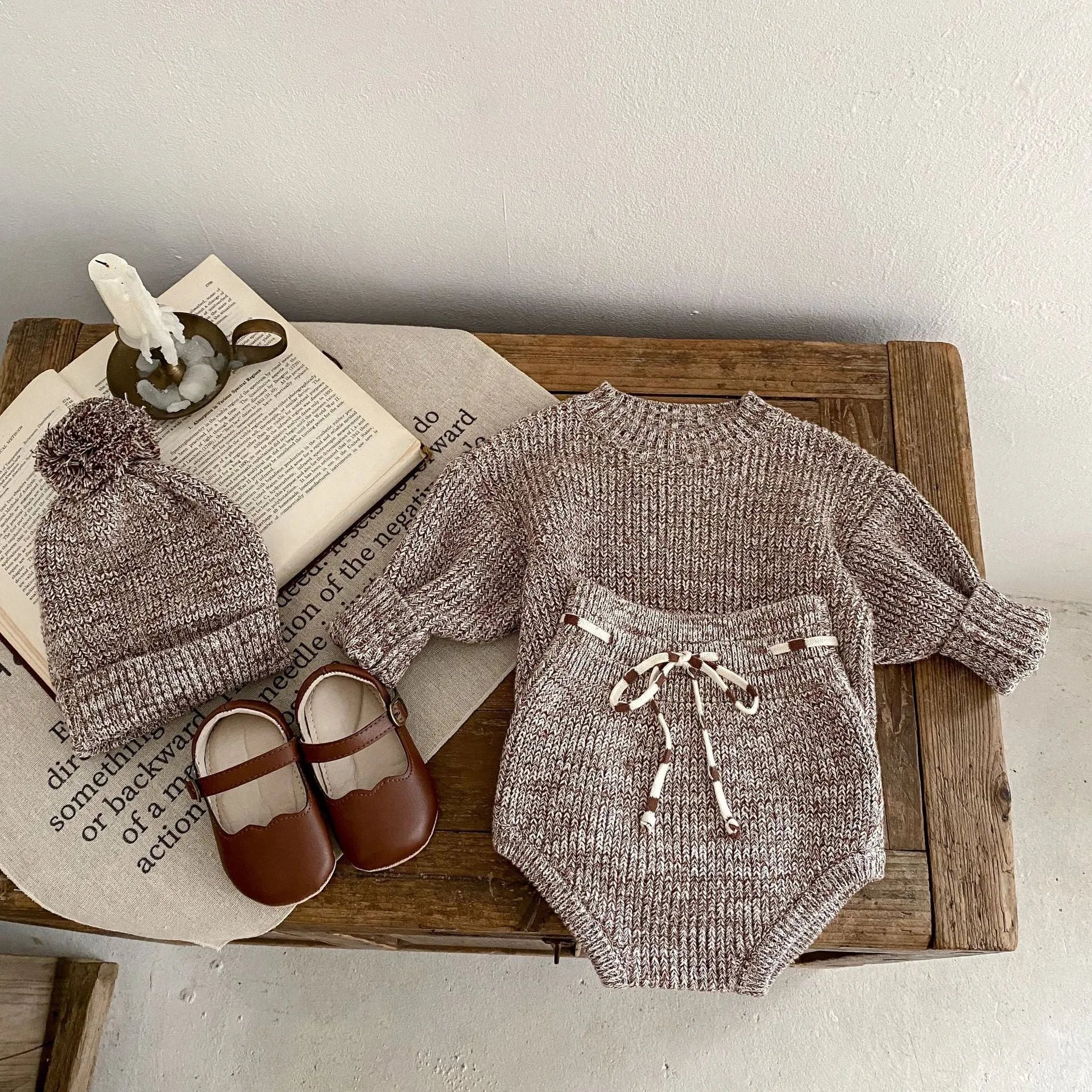 Dark brown knitted baby girl three-piece set with removable fur ball hat, blouse, and shorts