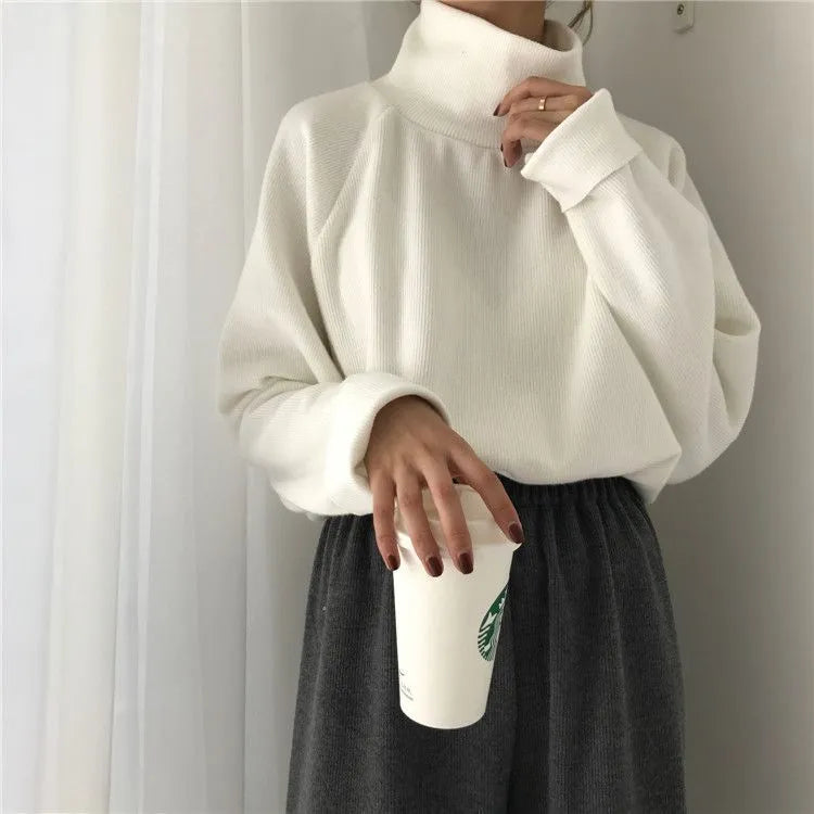 Women's solid colour loose-fit long sleeve top with a half-high collar in white, apricot, or black.