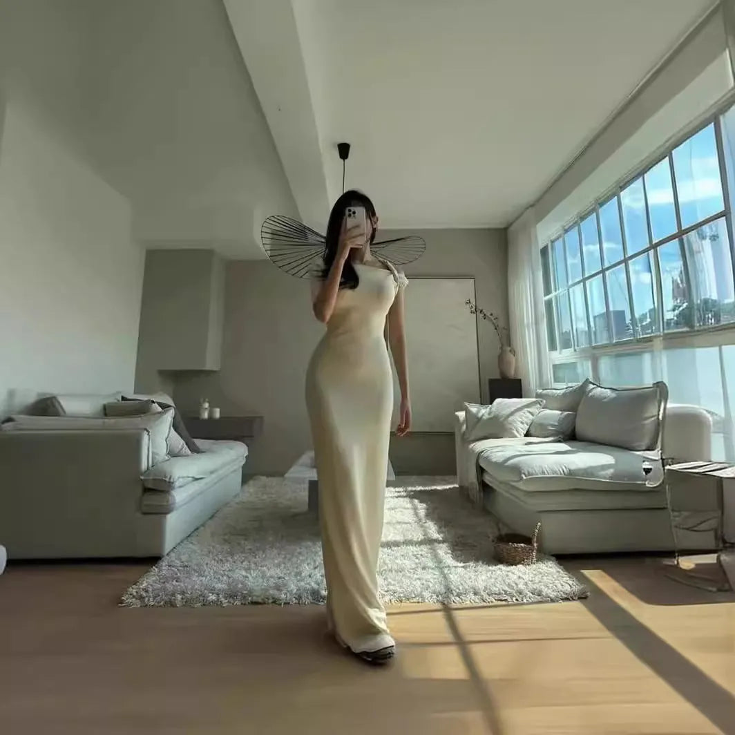 White sleeveless sloping shoulder long dress with high waist, hip skirt shape and fold detail in polyester