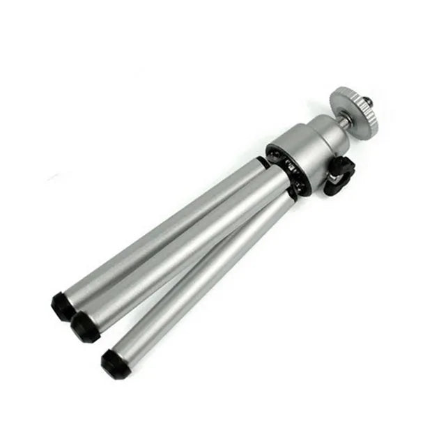 Black mini desktop camera tripod with extended legs and a U-shaped phone clip attached, on a white background.