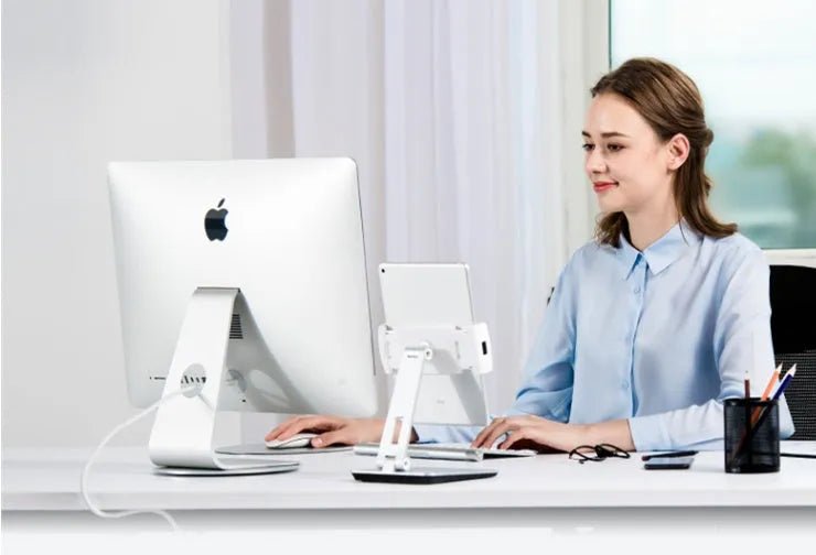 Folding aluminium desktop stand holding a tablet, showing its 360-degree rotation hinge and black/silver colour options.