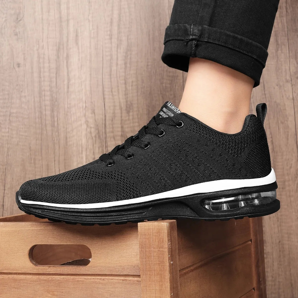 Pair of grey and black Flyknit mesh running shoes with a round toe and PU sole on a white background.