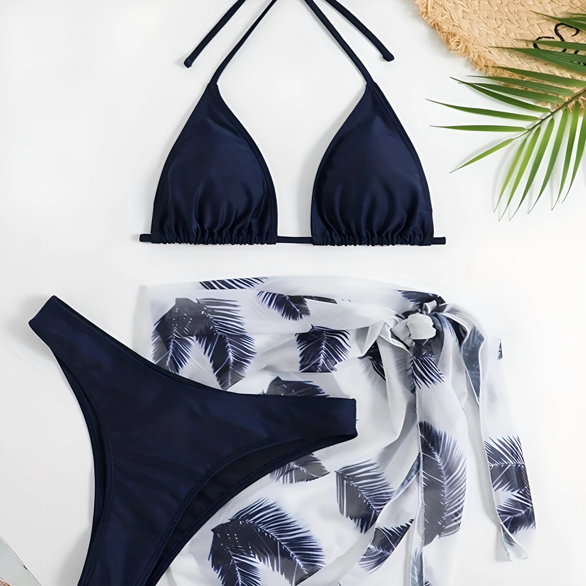 Orange three-piece bikini swimsuit set with a matching printed gauze skirt laid flat.