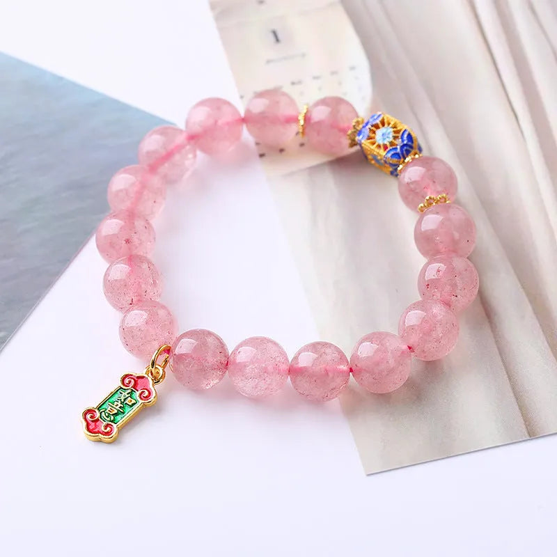 Pink strawberry quartz crystal bracelet with hand-woven construction and traditional Chinese ruyi lucky symbols